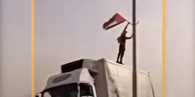 Le chauffeur d’un camion israélien remplace les drapeaux israéliens sur l’autoroute par des drapeaux de l’OLP