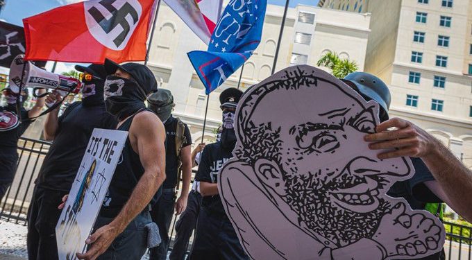 Des néo-nazis américains manifestent avec drapeaux et insignes nazis face au meeting politique de Donald Trump