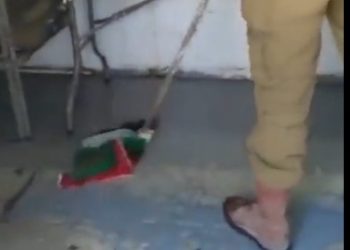 Un soldat de Tsahal passe la serpillière avec un drapeau palestinien